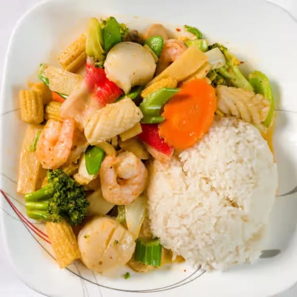 A vibrant Thai seafood stir-fry with shrimp, scallops, and vegetables, served with white rice.