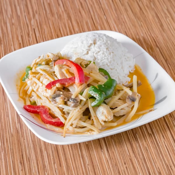 Thai red curry with chicken, bamboo shoots, bell peppers, and mushrooms, served with white rice.